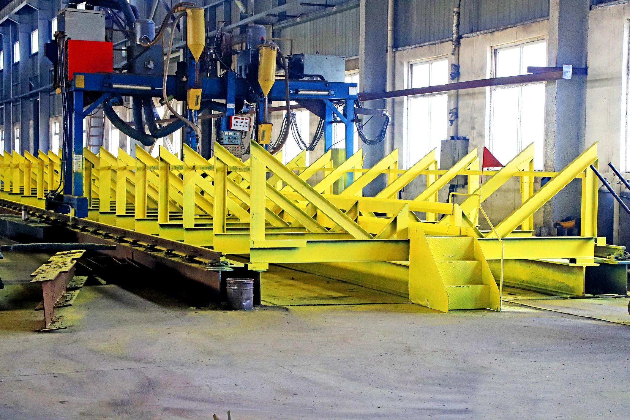 Automated industrial machine operating over a steel assembly line